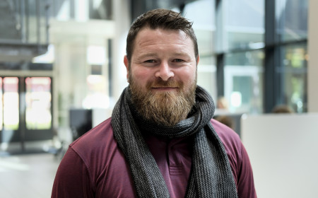 Pædagogstuderende står og smiler