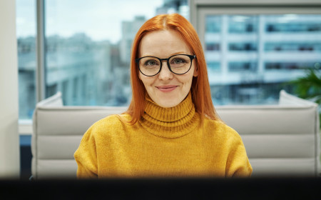 Sundhedsadministrativ koordinator sidder bag computer og velkomstskranken