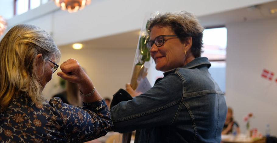 Ida Jager er færdiguddannet pædagogisk assistent og giver coronavenligt "knus" med sin underviser