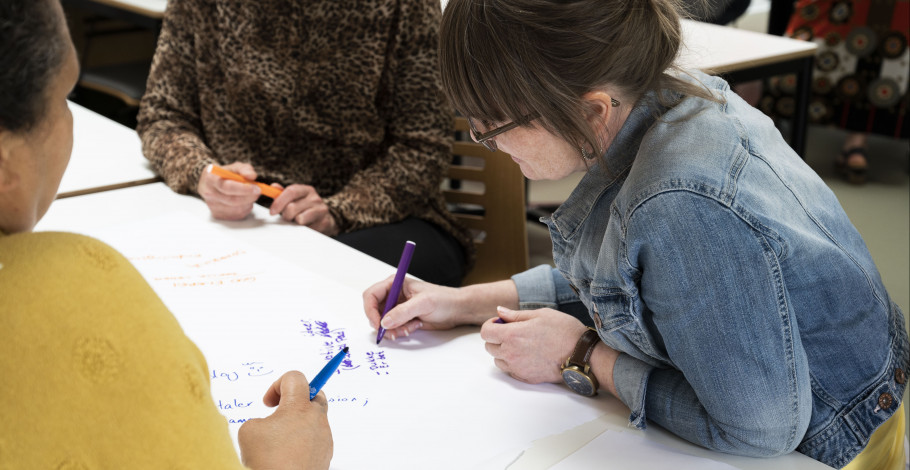 Gruppearbejde på meritpædagoguddannelsen, hvor studerende skriver på papir sammen